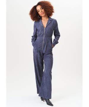 Dieser blaue Cord-Jumpsuit mit langen Ärmeln und praktischem Reißverschluss auf der Vorderseite kombiniert Komfort mit einem lässigen Stil. Der weiche Stoff und die lockere Passform machen ihn perfekt für den Alltag, während der Reißverschluss vorne Ihrem Look einen modernen Touch verleiht. Ideal für alle, die mühelosen Stil suchen, ohne auf Komfort verzichten zu müssen.