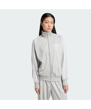 The adidas Firebird track suit has been making an impact for over 50 years. This updated track top continues the legacy with a loose shape for a laid-back vibe. Signature 3-Stripes slide down the sleeves, and a small Trefoil sits over the heart. Shiny tricot fabric keeps the look classic.This product is made with 100% recycled materials. By reusing materials that have already been created, adidas help to reduce waste and our reliance on finite resources and reduce the footprint of the products adidas make.  - Loose fit - Full zip - 100% polyester (recycled) - Side pockets - Wide cuffs and hem  Shipped by adidas