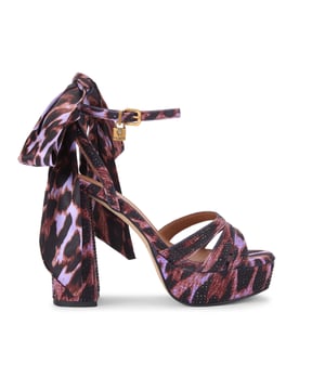 This Brixton Platform is a purple fabric which is embellished with antique brass crystal. There is a silver padlock detail and satin scarf on the ankle straps. Heel height: 11.5cm.