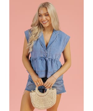 Top babydoll de denim en lavado claro  
Escote en V profundo  
Dobladillo peplum  
Detalles de manga tipo músculo  
Diseño sin mangas  
Diseño en capas juguetón  
Cuello  
Material: 82% Algodón 10% Poliéster 8% Viscosa