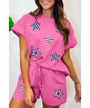 Gráfica inspirada en la bandera americana con estrellas de lentejuelas cosidas en el frente. Conjunto casual de 2 piezas que incluye una camiseta holgada y pantalones cortos con cordón. Fabricado con materiales de calidad y una base de color sólido. Presenta una textura moderna.