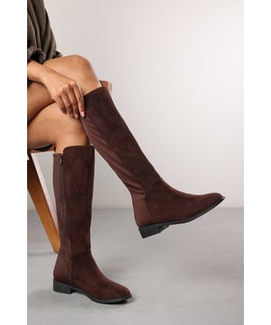 Stay effortlessly chic in our Parker Knee High Boots With Side Zip, designed with a sleek silhouette and flexible elastic panel for the perfect fit. The wedge heel offers subtle lift and support, while the side zip makes them easy to slip on and off. Ideal for day-to-night wear, these boots pair beautifully with everything from dresses to denim. Key Features: • Material: Soft faux suede with stretch elastic panel • Design: Knee-high boots with wedge heel and streamlined shape • Closure: Side zipper for easy wear
