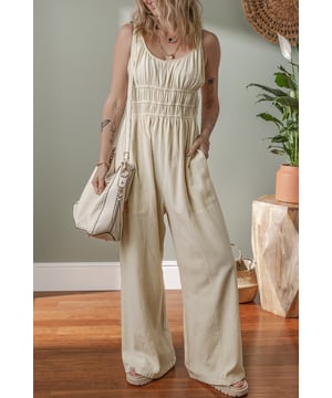 Beige geraffte High-Waist ärmellose weite Jumpsuit  
Flatternde geraffte Details fügen Textur und Dimension hinzu  
Einfarbiges Design bietet endlose Styling-Möglichkeiten  
Das High-Waist-Design definiert die Taille und verlängert die Silhouette  
Ärmellose Silhouette sorgt für ein modernes und luftiges Gefühl  
Material: 100 % Baumwolle