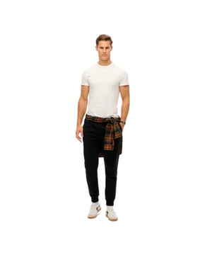 Jogging Superdry Essential Homme Noir Coton. Authentique Vetement de la marque Superdry - design streetwear/sportswear de Superdry - Superdry pour Homme fashion, parfait pour la vie de tous les jours - Jogging Superdry de couleur Noir s'associe parfaitement avec le reste de votre dressing - matiere Coton confortable -   classic - Essential -
