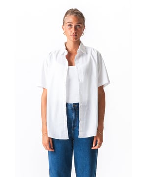 Elegancia sin Esfuerzo: Tu Nueva Camisa Favorita de Lino Blanco

Adéntrate en la sofisticación fresca con la Camisa de Lino de Manga Corta de TeeShoppen. Diseñada para la mujer moderna que valora tanto el estilo como la comodidad, esta no es una camisa blanca cualquiera; es una prenda versátil para tu armario, diseñada para que te veas y te sientas impecable, temporada tras temporada.

Experimenta la Fusión Perfecta de Comodidad y Estilo

Imagina la sensación de una tela ligera que se extiende con elegancia, manteniéndote fresca incluso en los días más calurosos. Esa es la magia de nuestra mezcla cuidadosamente seleccionada de 70% Algodón y 30% Lino. Hemos combinado la frescura y la transpirabilidad del lino con la suavidad y comodidad del algodón. Esta cuidada mezcla ofrece lo mejor de ambos mundos:

Transpirable: El lino permite que el aire circule libremente, evitando el sobrecalentamiento y garantizando comodidad durante todo el día. Tacto suave: La adición de algodón de alta calidad garantiza una sensación más suave al tacto que el lino puro, reduciendo la rigidez.
Caída elegante: La mezcla de telas tiene una caída hermosa, ofreciendo una silueta favorecedora sin ceñirse.
Cuidado más fácil: Disfruta del sofisticado aspecto del lino con menos arrugas y un cuidado más fácil gracias a la mezcla de algodón.
Diseñado para la versatilidad, hecho para ti.