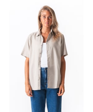 Escapa de lo común y adopta un estilo chic sin esfuerzo con la camisa de lino de manga corta TeeShoppen en un hermoso tono arena. No es una blusa cualquiera; es tu prenda ideal para una comodidad transpirable y una elegancia discreta, diseñada específicamente para la mujer moderna que busca un estilo versátil.

¿Por qué te encantará esta camisa de mezcla de lino?

Experimenta la fusión perfecta de estilo y comodidad. Confeccionada con una mezcla premium de 70 % algodón y 30 % lino, esta camisa ofrece lo mejor de ambos mundos, brindando una sensación de lujo sin comprometer la practicidad. Siente la tela suave y transpirable en tu piel, ideal para mantenerte fresca y cómoda incluso en los días más cálidos. El algodón proporciona estructura y una suavidad duradera, mientras que el lino añade esa textura ligera y sutil caída distintiva, creando un look relajado pero refinado. Olvídate de las arrugas excesivas del lino puro; esta mezcla cuidadosamente equilibrada está diseñada para ser fácil de usar y de cuidar, convirtiéndola en una prenda imprescindible en tu armario. El versátil color Arena, un beige cálido y neutro, evoca playas soleadas y combina a la perfección con casi cualquier prenda de tu armario.

Características y beneficios clave:
Transpirable: Las propiedades naturales de la mezcla de algodón y lino permiten la libre circulación del aire, manteniéndote fresco, seco y cómodo durante todo el día.