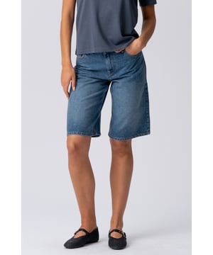 Sumérgete en el verano con los pantalones cortos vaqueros azules esenciales de TeeShoppen

Descubre tu estilo veraniego definitivo con los pantalones cortos vaqueros en el clásico azul de TeeShoppen: tu nueva prenda imprescindible para un estilo desenfadado y comodidad durante todo el día. Diseñados específicamente para la mujer moderna que busca versatilidad sin renunciar a la calidad, estos pantalones cortos son más que una simple prenda; son una declaración de confianza despreocupada y un atractivo atemporal. Imagina días frescos, aventuras espontáneas y una apariencia impecablemente fresca. Esa es la promesa de estos pantalones cortos vaqueros de confección perfecta.

Creemos que el verdadero estilo comienza con una comodidad excepcional. Por eso, nuestros pantalones cortos vaqueros están meticulosamente confeccionados para que no solo se vean fantásticos, sino que se sientan increíbles desde el momento en que te los pongas hasta el final de tu día soleado.

Elegancia diaria sin esfuerzo: Combínalos con una camiseta básica blanca impecable de TeeShoppen, tus zapatillas favoritas y unas gafas de sol extragrandes para un look fresco y elegante al instante. Perfecto para hacer recados, tomar un café o una comida informal con amigos.
Soñadora bohemia: Combina tus pantalones cortos con una blusa bordada y vaporosa, sandalias cómodas y un montón de pulseras delicadas. Ideal para mercados de fin de semana, conciertos al aire libre o simplemente para transmitir un espíritu relajado y libre.