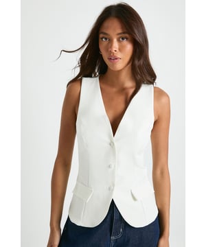 Sleek tailored waistcoat with distinctive button trim detailing
        V-neckline with crew neck back for a contemporary silhouette
        Functional front pockets add practical style elements
        Structured fit with subtle stretch for comfortable movement
        Versatile sleeveless design perfect for layering or standalone wear
    
    This Button Trim Detail Tailored Waistcoat from Boohoo brings sophisticated structure to your going-out wardrobe. The clean lines and tailored silhouette create a refined look that works brilliantly for evening occasions. Style with dark wash denim as shown for a smart-casual ensemble that transitions effortlessly from drinks to dancing. For a more dramatic nightlife look, layer over a sheer blouse or wear with nothing underneath for a daring statement. The versatile design also pairs wonderfully with tailored trousers and heels for more upscale venues. The button detailing adds visual interest while maintaining the waistcoat's sleek profile. This piece offers the perfect balance of classic tailoring and contemporary styling-an essential addition to your night-out collection that will become a go-to for countless evening events.