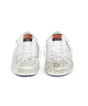 Low-Top-Sneaker mit goldenen Farbspritzern. Aus Glattleder. Used-Effekte. Schnürung vorne. Die Sohle hat einen gealterten Look, der jedes Teil einzigartig macht. Bitte beachten Sie, dass der Artikel ungetragen ist, die Verpackung jedoch durch den Versand leicht beschädigt sein kann.