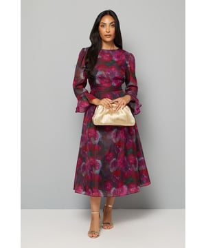 Elegant floral organza midi dress with sophisticated crew neckline
        Romantic flute sleeves with delicate ruffle detail for a feminine touch
        Flattering cinched waist design enhances your silhouette
        Flowing midi-length skirt with gentle movement for graceful appeal
        Fully lined for comfort and perfect drape
    
    This enchanting Petite Floral Organza Midi Dress from Wallis captures sophisticated glamour with its delicate floral pattern and ethereal organza fabric. The flute sleeves add a romantic flourish while the midi length ensures a timelessly elegant silhouette. Perfect for special occasions, style with metallic heeled sandals and a coordinating clutch bag as shown for wedding guest perfection. The lightweight, flowing fabric creates beautiful movement as you walk, while the crew neckline offers a classic finish. For cooler evenings, layer with a tailored cropped jacket or elegant wrap. This versatile piece transitions beautifully from daytime garden parties to evening celebrations, making it a standout addition to your occasion wardrobe that promises to turn heads whilst maintaining sophisticated comfort.