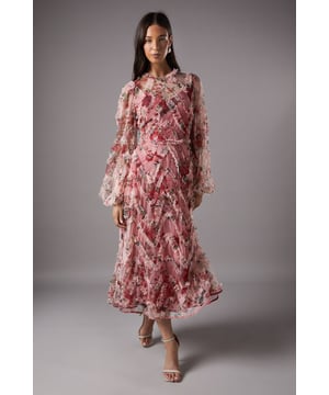 Exquisite floral appliqu detailing creates a stunning three-dimensional effect across the dress
        Elegant round neckline frames the dcolletage beautifully
        Flowing midi length with a graceful A-line silhouette
        Delicate mesh fabric offers a light, ethereal quality
        Statement long sleeves with voluminous cuffs add dramatic flair
    
    This enchanting Coast midi dress showcases remarkable craftsmanship with its intricate floral appliqu detailing that catches the light with every movement. The sheer mesh overlay creates a dreamy, weightless effect whilst the round neckline and long billowing sleeves offer a sophisticated silhouette. Perfect for wedding celebrations or race day events, this dress commands attention without overwhelming. Style with minimal strappy heels as shown and delicate drop earrings to maintain the dress as the focal point. For cooler occasions, drape a lightweight pashmina over your shoulders. The midi length provides versatility for various formal settings, whilst the dimensional floral elements ensure you'll stand out amongst the crowd with refined elegance.