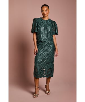 Luxurious PU midi skirt featuring intricate lace overlay with botanical pattern
        Elegant scalloped hem detail adds a refined finishing touch
        Figure-flattering silhouette with a sophisticated midi length
        Designed specifically for petite frames for perfect proportions
        Semi-sheer lace detailing creates a striking textural contrast
    
    This exquisite Petite PU Lace Midi Skirt from Coast combines contemporary style with timeless elegance. The striking botanical lace overlay creates a captivating visual texture whilst the scalloped hem adds a touch of femininity to this sophisticated piece. Perfect for special occasions, this skirt pairs beautifully with a simple silk camisole and strappy metallic heels as shown for a wedding guest ensemble that commands attention. For race day events, complement with a tailored blazer and fascinator for a look that balances tradition with modern flair. The midi length is particularly flattering on petite frames, whilst the PU fabrication offers structure and durability. This versatile piece transitions effortlessly from formal daytime events to evening soires, making it a valuable addition to your occasion wardrobe.