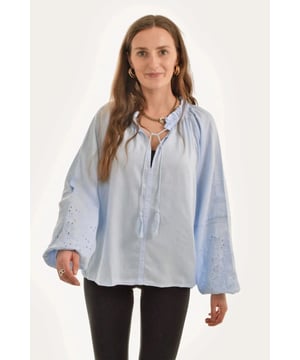 Feminine Blouse in a soft weave with broderie anglaise and hole-embroidered sections at the front and down the sleeves. Opening at the top and a wide, elasticated neckline with a decorative drawstring. Long, wide raglan sleeves with elasticated cuff / sleeve. Longer at the back with a rounded hem.