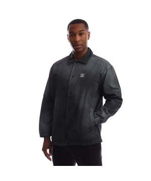 Mens adidas Originals Essentials+ Dye Coach Shirt in black - white. The unique garment-dye approach on this adidas shirt gives them a faded effect for a look and feel of ease. Soft cotton twill layers casually thanks to the loose fit. Play it up or down — the soft colour adds to the vibe however you style it. - A garment-washed shirt for a laid-back vibe.- Snap button front.- Fold-down collar.- Front pockets.- Trefoil logo at left chest.- Loose fit.- Main material: 100% Cotton.  Machine washable.- Ref: HK7513