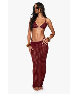Shimmering rhinestone embellishments for a touch of glamour
        Mesh fabric offers a lightweight and breathable feel
        Triangle bikini top with adjustable straps for a customised fit
        Full-length skirt with a figure-hugging silhouette
        Versatile two-piece set perfect for beach-to-bar transitions
    
    Make a statement on your next seaside getaway with this eye-catching beach skirt set from Boohoo. The mesh fabric ensures comfort and breathability, while the sparkling rhinestones add a dash of allure to your beachside ensemble. The triangle bikini top offers support and adjustability, complementing the full-length skirt that gracefully skims your curves. Style this set with metallic sandals and oversized sunglasses for a chic daytime look. As the sun sets, throw on some statement earrings and slip into wedges to effortlessly transition from beach lounging to casual evening drinks. This versatile piece is ideal for those who want to shine at beach parties, poolside gatherings, or casual resort dinners, embodying the perfect blend of comfort and style for the fashion-forward holidaymaker.