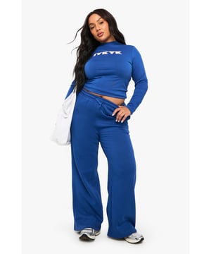 Wide leg design for maximum comfort and on-trend silhouette
        Soft cotton fabric provides breathable all-day wear
        Decorative bow detail adds a feminine touch to casual styling
        Coordinated top and bottom set creates an effortless matching look
        Bold graphic text detail for contemporary street style appeal
    
    These Boohoo Plus wide leg joggers blend comfort with contemporary style for the fashion-forward woman. The relaxed wide leg silhouette offers unrestricted movement whilst maintaining a trendy profile that works brilliantly for casual outings. Style them as seen with the matching top for a coordinated ensemble, or pair with a cropped tee for a more laid-back approach. The bow detail adds a subtle feminine element to an otherwise sporty piece. Perfect for weekend coffee runs, casual meet-ups with friends, or lounging at home in style. These versatile joggers transition effortlessly from daytime errands to evening relaxation - simply swap your trainers for sliders and add a denim jacket when temperatures drop. An essential addition to your casual wardrobe that combines comfort with Boohoo's signature contemporary flair.