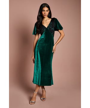 Sumptuous velvet midi dress with elegant lace detailing at the bodice
        Flattering V-neckline complemented by feminine flutter sleeves
        Figure-enhancing silhouette with a graceful midi length
        Sophisticated lace panel detailing adds textural contrast
        Fully lined for comfort and a smooth fit
    
    Make a striking impression at your next special occasion with this Coast Velvet Lace Mix Midi Dress. The luxurious velvet fabric creates a rich textural effect whilst the delicate lace detailing at the bodice adds a touch of romance. The flutter sleeves provide just the right amount of coverage, whilst the V-neckline frames the dcolletage beautifully. Style with metallic strappy heels as shown for formal events such as weddings or race day. Add a structured clutch and statement earrings to complete your ensemble. This versatile piece transitions effortlessly from day to evening occasions, making it a valuable addition to your occasion wardrobe. The midi length offers a contemporary yet timeless silhouette that flatters all figures, whilst the subtle stretch in the fabric ensures comfort throughout your event.