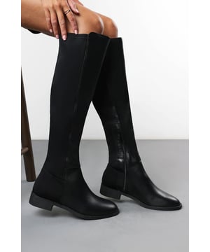 Step into timeless elegance with our Verity Stretch Over Knee Flat Riding Boots. Designed with a sleek silhouette and smooth finish, these boots offer a perfect blend of style and comfort. The over-the-knee length creates a flattering, elongated look, while the low block heel ensures all-day wearability. Complete with an inner side zip for ease and a stretch panel for a comfortable fit, they’re ideal for pairing with skinny jeans, leggings, or dresses for a chic seasonal look. Key Features: • Material: Smooth faux leather for a refined finish • Design: Sleek over-the-knee style with stretch back panel • Closure: Inner side zip for convenience