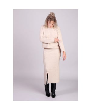 
Ben je op zoek naar een trendy en vrouwelijke aanvulling op je garderobe? De gebreide kokerrok Nasta van Grace & Mila is de perfecte mix van stijl en comfort, ideaal voor het tussenseizoen. De rok heeft een flatterende, slanke en rechte snit en elegante split aan de voorkant. De beige gebreide rok is gemaakt van een luxe wolmix en is gebreid met een verfijnd ribdetail.
Combineer de Nastia kokerrok met de bijpassende oversized trui Nassim van Grace & Mila voor een complete monochrome look. 
Product details:

Koker gebreide rok
Split aan de voorkant
Rechte snit
Gemaakt van een zachte wolmix
26% acryl, 27% polyester, 20% nylon, 15% wol, 2% elastaan.
Lengte van de rok is 84cm
De Nastia rok valt op maat. Het model is 1,75 m lang, met een tailleomvang van 58 cm en heupomvang van 86 cm, en draagt maat S.
Was de gebreide rok op lage temperatuur of handwas

