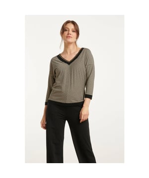 
Voeg een vleugje elegantie toe aan je garderobe met de Smashed Lemon zwart-gouden top met een subtiele chevron streepprint. Deze top is ontworpen met een v-halslijn, afgewerkt met een zwart ribgebreide boord voor een stijlvolle uitstraling. De 3/4 mouwen en de losse pasvorm zorgen voor een comfortabele en trendy look, ideaal voor zowel casual als meer geklede gelegenheden. De top is gemaakt van 75% viscose, wat zorgt voor een zachte en ademende stof die aangenaam aanvoelt op de huid. Perfect te combineren met een nette broek of een jeans voor een veelzijdige outfit. Deze top is een must-have voor vrouwen die van mode en comfort houden. Belangrijkste kenmerken: - V-halslijn met zwart ribgebreide boord - 3/4 mouwen en een losse pasvorm - Gemaakt van 75% viscose voor een zacht en ademend gevoelSpecificaties :

 
 * Stijl: tops 
 * Print: Strepen 
 * Pasvorm: losvallend 
 * Lengte: kort 
 * Model is : 174 cm tall and wears size S/36 
 * Country of Origin: Made in Turkey 
 * Kleur: Zwart,