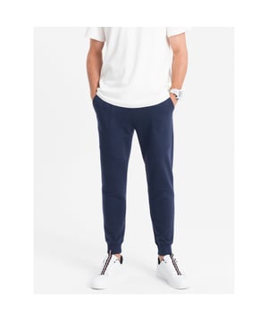
Heren joggingbroek van het Fashion Italia merk Ombre. De mannen broek is gemaakt van zachte aangename joggingstof. Ook heeft de loungebroek heren een normale pasvorm. Deze joggingbroek heren is ideaal voor thuis en casual gebruik.

 Merk: Ombre
 Pasvorm: Normal Fit
 Materiaal: 65% Katoen 35% Polyester
 Kleur: Donkerblauw
 Sportcategorie: Fitness
 Tailleband: Verstelbaar, elastisch
 Sluiting: Met koordsluiting
 Zakken: Steekzakken
 Patroon: Effen
 Details: Elastische tailleband

 Artikelnummer: OM-22FW-008 Hoogte model: 179 cm.
 Het model presenteert het product in maat: M