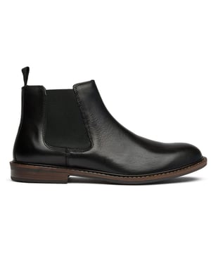 El SOLETRADER Steve Chelsea aporta una sofisticación atemporal a tu rotación diaria. Confeccionadas con superiores de cuero premium y una clásica punta redonda, estas elegantes botas de tobillo negras se deslizan fácilmente gracias a su estilo clásico de chelsea. La suela sintética proporciona un agarre confiable mientras mantiene la silueta refinada de la bota. Un esencial versátil que transpone sin esfuerzo de las reuniones de oficina a las salidas de fin de semana.
