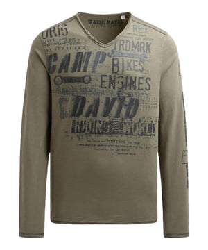 Dieses Camp David Langarmshirt für Herren vereint lässige Coolness mit hochwertigem Tragekomfort und wird schnell zu einem unverzichtbaren Bestandteil Ihrer Casual-Garderobe. Die plakativ gestalteten Label-Prints mit Used-Optik auf Vorderseite, Rücken und Ärmeln ziehen sofort alle Blicke auf sich und verleihen dem Langarmshirt einen modernen, individuellen Charakter, während die markanten Kontrastnähte an Schultern und Seiten für ein dynamisches, stylisches Detail sorgen. Die Flammgarnstruktur verleiht dem Material eine besondere Haptik und einen subtilen Vintage-Look, während der V-Neck-Ausschnitt eine legere Eleganz ausstrahlt und perfekt mit den offenen Kanten an allen Säumen harmoniert. Dank der Regular Fit Passform sitzt das Langarmshirt komfortabel, ohne einzuengen, und bietet Bewegungsfreiheit für den Alltag oder entspannte Wochenenden. Hergestellt aus sorgfältig ausgewählten, hochwertigen Materialien, garantiert es ein angenehmes Hautgefühl, Langlebigkeit und Strapazierfähigkeit. Ob zu Jeans, Chinos oder Shorts getragen, dieses modische Langarmshirt vereint Style und Komfort mühelos, passt ideal zu einem lässigen Casual-Look und wird schnell zu einem vielseitigen Favoriten, der jedem Outfit eine markante, maskuline Note verleiht.