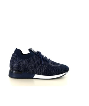 
De La Strada 2400409 instap sneaker combineert moeiteloos stijl en comfort voor de moderne vrouw. Het bovenwerk is vervaardigd uit hoogwaardig stretchmateriaal, wat zorgt voor een flexibele pasvorm die zich perfect aanpast aan de contouren van je voet. De diepe '4560 dark blue' kleur geeft de sneaker een elegante en tijdloze uitstraling, ideaal voor zowel casual als meer geklede gelegenheden.Ontworpen met een elastische instap en een decoratieve rijgveter, biedt deze sneaker niet alleen een modieuze look, maar ook praktisch gemak. Je kunt de schoen eenvoudig aan- en uittrekken, terwijl de elastische constructie zorgt voor een aansluitende en comfortabele fit gedurende de dag.Een opvallend kenmerk van de La Strada 2400409 is de uitneembare binnenzool. Dit maakt het mogelijk om je eigen steunzolen te gebruiken, wat essentieel is voor degenen die behoefte hebben aan extra ondersteuning of orthopedische inlegzolen prefereren.La Strada, opgericht in Waalwijk, heeft zich ontwikkeld tot een bekend schoenenmerk in zowel Nederland als daarbuiten. Het merk staat al meer dan 25 jaar bekend om topkwaliteit en biedt haar schoenen aan voor een aantrekkelijke prijs. Elke collectie is afgestemd op de laatste schoenentrends, waardoor La Strada een merk is waar je mee opvalt.