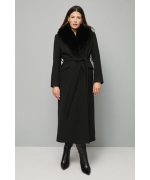 Luxurious faux fur collar adds dramatic sophistication to this full-length coat
        Flattering tie belt design accentuates the waist for a feminine silhouette
        Full-length cut offers maximum coverage and warmth during colder months
        Practical side pockets provide convenient storage for essentials
        Versatile regular fit allows for comfortable layering over smart or casual outfits
    
    Make a striking entrance at any formal occasion with this sophisticated Wallis coat. The sumptuous faux fur collar creates a glamorous frame for your face, whilst the tie belt cinches the waist beautifully for a flattering shape. The maxi length offers both warmth and drama, perfect for evening events when paired with a sleek dress and heeled boots as styled in the image. For daytime sophistication, layer over tailored trousers and a fine knit jumper. The clean lines and classic silhouette ensure this coat will remain a wardrobe staple for years to come, effortlessly transitioning from smart casual gatherings to more formal affairs. This coat truly embodies the Wallis ethos of sophisticated glamour without compromising on comfort - an investment piece that will serve your wardrobe faithfully through countless winter seasons.