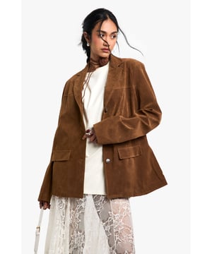Oversized silhouette for a relaxed, on-trend look
        Faux suede fabric with a vintage-inspired texture
        Notched lapels and single-breasted button closure
        Functional front flap pockets for practicality
        Versatile design suitable for various casual occasions
    
    Embrace the vintage charm with this oversized blazer in faux suede. The relaxed fit and textured fabric create a laid-back yet stylish appearance perfect for the fashion-forward woman. Style it with a crisp white top and lace skirt for a chic contrast of textures. This blazer is ideal for casual outings, family gatherings, or a relaxed day at the office. Pair it with straight-leg trousers and loafers for a smart-casual look, or throw it over a simple dress and trainers for an effortless weekend ensemble. The versatility of this piece allows for endless styling options, making it a must-have addition to your wardrobe. Its oversized nature adds a contemporary edge to any outfit, ensuring you stay on-trend while maintaining comfort.