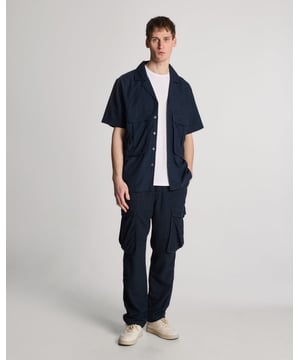 Verrijk je garderobe met ons overhemd met reverskraag van katoen en linnen, een onberispelijke aanvulling op de High Summer-collectie. Gemaakt van een luxueuze mix van 40% rayon, 31% linnen, 26% katoen en 3% spandex, combineert dit relaxed-fit overhemd moeiteloos comfort met verfijning, waardoor het ideaal is voor elke chique gelegenheid. - Premium katoen-linnenmix - Relaxte pasvorm voor moeiteloze elegantie - Veelzijdige styling voor casual of semi-formele uitjes - Discrete logo-branding voor subtiele verfijning - Perfect voor de lentecollectie van de moderne heer Omarm tijdloze stijl en verfijning dit seizoen met ons overhemd met reverskraag van katoen en linnen, een essentieel kledingstuk voor veeleisende smaak.