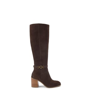 This Kurt Geiger Bromley Knee High Boot is crafted from a brown suede leather. There is a circular antiqued brass chain trim on the outer side of the ankle. The block heel is in a wooden style. Heel height: 8cm.