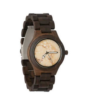 
De 1915 Watch Lady Elegance Rusty Stone is een ware belichaming van natuurlijke schoonheid en elegantie. Dit dameshorloge onderscheidt zich door zijn unieke materiaalcombinatie, waarbij vakmanschap en natuur harmonieus samensmelten. Het hart van het horloge is vervaardigd uit sandelhout, bekend om zijn diepe, natuurlijke kleurtinten. Wat dit horloge bijzonder maakt, is het feit dat er geen verf, lak of beits is gebruikt om de kleur te verkrijgen – het is puur natuur. Deze keuze voor sandelhout draagt niet alleen bij aan de esthetiek van het horloge maar benadrukt ook een diepe waardering voor de natuurlijke schoonheid van het materiaal. De wijzerplaat krijgt extra karakter door de toevoeging van een dun laagje echt natuursteen. Dit element brengt een unieke textuur en uitstraling met zich mee, waardoor het horloge een opvallend en verfijnd accessoire wordt. Het natuursteen, in combinatie met het donkere sandelhout, creëert een balans tussen robuustheid en finesse. Qua afmetingen heeft de horlogekast een diameter van 38mm, perfect voor een elegante, vrouwelijke pols. De band, met een breedte van 21mm, biedt verder het comfort van aanpasbaarheid. De horlogeband kan naar wens worden aangepast door schakels te verwijderen, een proces dat eenvoudig is dankzij de metalen pinnetjes die in sommige schakels kunnen worden uitgedrukt. Samenvattend is de 1915 Watch Lady Elegance Rusty Stone een verbluffend staaltje van hoe natuurlijke materialen en verfijnd design samen een tijdloos sieraad kunnen vormen, perfect voor de moderne vrouw die zowel elegantie als authenticiteit hoog in het vaandel heeft.