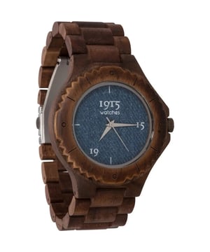 
Gecreëerd door de innovatieve geesten van de Bollenstreek broers, Johnny & Robert Spies, belichaamt de 1915 Watch Men Denim niet alleen een horloge, maar een verhaal van durf, design en duurzaamheid. Met een duidelijke intentie om de horlogemarkt te vernieuwen, zetten de broers Spies zich aan de keukentafel met een missie: het ontwerpen van unieke, duurzame horloges die zich onderscheiden door hun minimalistische wijzerplaten en onconventionele materialen. Wat direct opvalt aan de 1915 Watch Men Denim is de stoere en onderscheidende esthetiek. Het is niet zomaar een horloge; het is het enige houten horloge waarbij de wijzerplaat verrijkt is met stoere denim stof. Deze fusie van materialen spreekt boekdelen over het innovatieve karakter van het merk. De keuze voor walnoothout voor het horloge is opzichzelf al een statement. Dit hout, bekend om zijn grove structuur, geeft het horloge een robuuste en enigszins verweerde look die doet denken aan gebruikt steigerhout, maar dan met het comfort en de verfijning die je van een premium horloge mag verwachten. Het walnoothout brengt een warme, natuurlijke tint in het ontwerp, waardoor het een perfect accessoire is voor elke outfit. De wijzerplaat, bekleed met stoere denim stof, maakt dit horloge echt uniek. Deze ongebruikelijke combinatie van materialen maakt de 1915 Watch Men Denim een must-have voor liefhebbers van denim en zij die een statement durven te maken met hun accessoires. De sportieve ring rond de wijzerplaat, stevig bevestigd aan de horlogekast, voegt een extra element van stijl en robuustheid toe. Met een kastdiameter van 46mm en een bandbreedte van 25mm heeft dit horloge een opvallende aanwezigheid aan de pols. De band, ook vervaardigd uit walnoothout, kan op maat gemaakt worden door het verwijderen van schakels; een handige feature die het draagcomfort verhoogt. In conclusie, de 1915 Watch Men Denim is niet alleen een tijdweergave-instrument, maar een uiting van persoonlijke stijl, innovatie en een diepe waardering voor unieke materialen en design. Het is een horloge dat zowel een gespreksonderwerp is als een trouwe metgezel voor de hedendaagse man.
