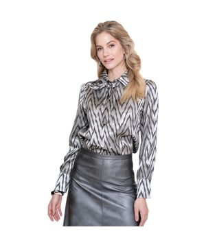 
De zilvergrijze blouse van Geisha heeft een subtiel dessin waarin zilver en zwart samen een glanzende structuur vormen, en de gladde stof voelt direct verfijnd aan op de huid. Het rechte model valt normaal en geeft ruimte om te bewegen. De bij geleverde band kun je als strik voor een zachte, vrouwelijke touch of als stropdas voor meer attitude dragen. Dankzij de mix van polyester en viscose behoudt de blouse haar vorm en valt de stof soepel over het lichaam, wat de natuurlijke lijnen van je outfit benadrukt zonder overdadig te zijn.