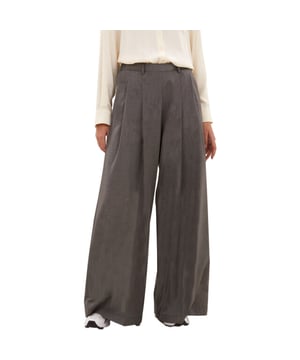 
Deze grijze pantalon van by-bar voelt meteen als een favoriete basis in je garderobe. De stof is een zachte mix van polyester en viscose die soepel valt en prettig meebeweegt. Dankzij de hoge taille en subtiele plooien aan de voorkant ontstaat een elegante, ontspannen lijn. De relaxed-vorm geeft ruimte, terwijl de normale pasvorm ervoor zorgt dat hij precies goed valt en comfortabel zit zonder te knellen. Achter voegt een elastische band extra gemak toe, terwijl de ritssluiting met knoop voor een nette afwerking zorgt.Daarnaast geven de wijd uitlopende pijpen en lange lengte beweging en een moderne, nonchalante look. Steekzakken houden je essentials bij de hand en geven tegelijk een speelse touch. Combineer de pantalon moeiteloos met sneakers voor casual dagen of met nette schoenen voor een chicere uitstraling. Kortom, deze pantalon brengt gemak en verfijning samen en laat je er moeiteloos stijlvol uitzien. Je stapt er iedere dag een tikje zelfverzekerder en vrolijker op uit.