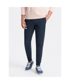 
Heren joggingbroek van het Fashion Italia merk Ombre. De mannen broek is gemaakt van zachte aangename joggingstof. Ook heeft de loungebroek heren een normale pasvorm. Deze joggingbroek heren is ideaal voor fitness en casual gebruik.

 Ombre Basic collectie
heren trainingspak joggingbroek
benen afgewerkt met een bies
decoratieve stiksels aan de zijkanten
twee steekzakken aan de voorkant
achterzak
trekkoord tailleband met geribbelde rand
zachte afwerking aan de binnenkant
subtiele branding - decoratieve oogjes en badge
Materiaal: 100% katoen
Kleur: marineblauw
Lengte van het model: 186 cm.
Het model presenteert het product in maat: M

 Artikelnummer: 0174-V1-NAV Houd je joggingbroek langer mooi!
Was joggingbroek binnenstebuiten op maximaal 30°C met gelijksoortige stoffen of in een waszak. 
Samen wassen met (ruwe) handdoeken of spijkerstof veroorzaakt slijtage en pluisvorming