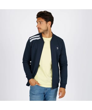 
Retro sportvest van sweatstof met witte details, ribboordkraag en ritssluiting. Afgewerkt met geborduurd Q-logo op de borst.. Het Tirns vest is een sportief heren vest met retro witte accenten en een comfortabele pasvorm. Gemaakt van fijne sweatstof afgewerkt met een frisse, sportieve look. Dankzij de ribboorden sluit het vest goed aan bij de hals, mouwen en onderzijde.

 De ritssluiting maakt het vest praktisch in gebruik en de ritszakken bieden ruimte voor kleine spullen. Op de borst is het vest afgewerkt met een subtiel geborduurd Q-logo. Draag hem casual of sportief!

 Beschikbare kleuren: Donkerblauw, Zwart (https://www.q1905.com/nl/heren-vest-tirns-zwart-158465054.html), Donkerrood (https://www.q1905.com/nl/heren-vest-tirns-donkerrood.html), Diepblauw (https://www.q1905.com/nl/heren-vest-tirns-diepblauw.html)
Bestel nu en ervaar de perfecte mix van stijl en comfort!
Ontdek ook onze andere heren vesten  (https://www.q1905.com/nl/heren/kleding/vesten)voor meer stijlvolle opties.