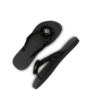 
A big stone positioned in the middle of the strap that will catch all the attention. The emblem in the circular stone portrays the Angel figure. The V are detailed with the signature Uzurii logo across the straps. Featuring an open toe, a slip-on style and a flat rubber sole. Rubber – PVC – Stones Platform height: 1,5cm The V (strap): Made in China Sole: Made in Brazil