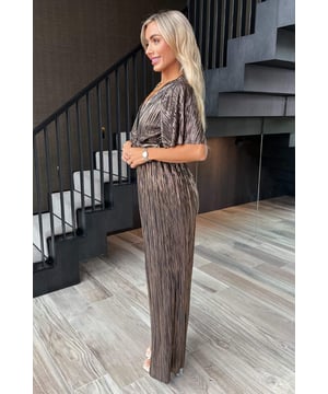 Our Bronze Plisse Buckle Detail Wrap Jumpsuit is this season's musthave. The wide leg jumpsuit features our premium plisse fabric, a wraptop, O-ring detail and flutter sleeves. Pair with some cute heels anda matching bag for a stunning party look.Model wears: UK 8/ EU 36/ US 4Model's height: 165cm/ 5'5"Approx length from centre back to hem: 152cmFabric composition: 100% PolyesterColour: BRONZE