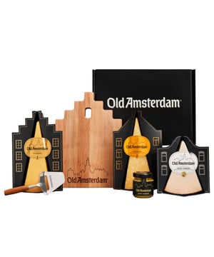 Verras met een smaakvol cadeau! De Party Package is een zorgvuldig samengestelde giftbox met de meest geliefde Old Amsterdam kazen, een smaakvolle chutney en stijlvolle accessoires. Ideaal voor een gezellige borrel of als bijzonder cadeau voor een echte levensgenieter. Een uniek geschenk waarmee je iemand echt kan verrassen! Drie iconische kazen: Old Amsterdam Classic, Goat en Vintage, met smaken die variëren van romig en mild tot intens en krachtig. Verfijnde toevoeging: Een zoete mosterdchutney die de rijke smaken van de kazen aanvult. Stijlvolle accessoires: Inclusief een authentiek gegraveerd kaasplankje in de vorm van een Amsterdams grachtenpand en een mini-kaasschaaf. Voor levensgenieters die van smaakvolle momenten houden De Old Amsterdam Party Package is meer dan een borrelpakket; het is een complete ervaring die traditie en innovatie samenbrengt. De kazen zijn met vakmanschap bereid volgens unieke recepten die door de jaren heen zijn verfijnd. Een cadeau dat indruk maakt Of je nu een feest organiseert of iemand wilt verrassen, deze set past bij iedere gelegenheid. Dankzij de stijlvolle verpakking en de veelzijdige kazen maak je van elke borrel een smaakvol feest. Liefhebbers Met de Old Amsterdam Party Package brengen we een stukje Nederlandse traditie en een verfijnde smaakervaring. Of het nu gaat om een borrelplank, een avond vol gezelligheid of een speciaal moment, dit pakket maakt het moment extra bijzonder.   Inhoud Old Amsterdam Classic 300 gram Old Amsterdam Vintage 300 gram Old Amsterdam Goat 220 gram Old Amsterdam zoete mosterdchutney 1x 45 gram Old Amsterdam kaasplankje Old Amsterdam mini kaasschaaf   Ingrediënten Old Amsterdam Classic: Gepasteuriseerde melk, zout, startcultuur (melk), stremsel, conserveermiddel (E251), kleurstof (carotenen) Old Amsterdam Vintage: Gepasteuriseerde melk, zout, startcultuur (melk), stremsel, conserveermiddel (E251), kleurstof (carotenen) Old Amsterdam Goat: Geitenmelk, zout, startcultuur (melk), microbieel stremsel Zoete mosterdchutney: Azijn, gele en bruine mosterdzaadjes, water, honing (8%), zeezout, rietsuiker, kurkuma Old Amsterdam Kaasplank: Beukenhout Old Amsterdam Kaaschaaf mini: RVS blad met beukenhouten handvat   Voedingswaarde De Old Amsterdam Classic bevat per 100 gram: 1788 kJ / 431 kcal energie, 35 gram vet waarvan 23,3 gram verzadigd vet, 0 gram koolhydraten waarvan 0 gram suikers, 29 gram eiwitten, 2,3 gram zout en 30 gram vocht. De Old Amsterdam Vintage bevat per 100 gram: 1862 kJ / 449 kcal energie, 37 gram vet waarvan 24,8 gram verzadigd vet, 0 gram koolhydraten waarvan 0 gram suikers, 29 gram eiwitten, 2,3 gram zout en 26,5 gram vocht. De Old Amsterdam Goat bevat per 100 gram: 1834 kJ / 443 kcal energie, 24,9 gram vet waarvan 24,9 gram verzadigd vet, 0 gram koolhydraten waarvan 0 gram suikers, 24,5 gram eiwitten, 2,5 gram zout en 31 gram vocht. De zoete mosterdchutney bevat per 100 gram: 610 kJ / 145 kcal energie, 7,7 gram vet waarvan 0,6 gram verzadigd vet, 11,3 gram koolhydraten waarvan 8,8 gram suikers, 5,7 gram eiwitten en 1,5 gram zout.   Allergenen: bevat koemelk, geitenmelk en mosterd.