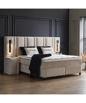 
Boxspring met opbergruimte Riviera De Boxspring met opbergruimte Riviera is zorgvuldig ontworpen om zowel luxe als praktische voordelen te bieden. Het bed beschikt over een imposant hoofdbord dat 90 cm breder is dan de matrasmaat, waardoor het een opvallend visueel element vormt en een gevoel van ruimte toevoegt aan je slaapkamer. Met een hoogte van 146 cm en een dikte van 22 cm biedt het hoofdbord een elegante uitstraling en extra comfort tijdens activiteiten zoals lezen of ontspannen in bed. De Riviera heeft een comfortabele instaphoogte van ongeveer 67 cm, wat het gemakkelijk maakt om in en uit bed te stappen. De combinatie van het 32 cm dikke pocketveringmatras en de HR-koudschuim topper zorgt voor optimale lichaamsondersteuning en slaapcomfort. Onder het bed bevindt zich geïntegreerde opbergruimte, ideaal voor het opbergen van extra dekens, kleding of accessoires. Dankzij een stevig frame van 28 cm hoog en robuuste stalen constructie is het bed zeer stabiel. De poten van 10 cm zorgen voor extra ventilatie onder het bed en maken schoonmaken eenvoudig. De Riviera boxspring biedt niet alleen uitstekende ondersteuning door de pocketvering, maar ook verkoelend comfort dankzij de koudschuim topper, wat bijdraagt aan een betere slaapervaring. Het bed is verkrijgbaar in diverse maten, geschikt voor iedere slaapkamer. Met hoogwaardige materialen en een stijlvolle beige kleur past dit bed perfect bij diverse interieurstijlen, van klassiek tot modern. Dankzij de praktische, geïntegreerde opbergruimte biedt het bed een slimme oplossing voor kleinere slaapkamers waar ruimte beperkt is. De Boxspring met opbergruimte Riviera combineert daardoor comfort, functionaliteit en elegantie in één stijlvol ontwerp.Specificatiesinclusief Pocketvering Hybride Matras 32 cmMateriaal: StaalKleur: BeigeAfmetingen: 160x200 cm