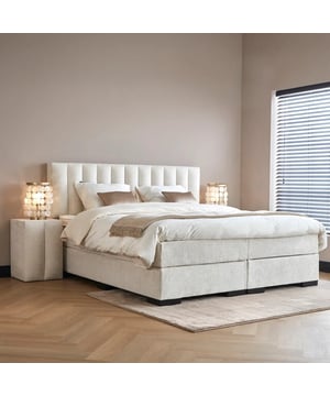 
Boxspring Amalia De Boxspring Amalia is een comfortabele en stijlvolle boxspring in zachte witte teddy stof. Verkrijgbaar in de maten 120×200, 140×200, 160×200, 160×210, 180×200 en 180×210 cm, past deze perfect in elke slaapkamer. Het hoofdbord is 10 cm breder dan het bed, 120 cm hoog en 15 cm dik, en biedt een robuuste uitstraling en comfortabele rugleuning. De hardebox van 26 cm hoog is gemaakt van duurzaam hout en rust op poten van 6 cm. Dit zorgt voor stabiliteit en een ideale instaphoogte. Het 19 cm dikke matras heeft een pocketveringkern die uitstekende ondersteuning biedt en bewegingen isoleert. De koudschuim afdeklaag zorgt voor extra comfort en goede ventilatie. De meegeleverde 5 cm dikke koudschuim-topper past zich aan het lichaam aan en biedt extra ondersteuning. De topper is afritsbaar en wasbaar voor eenvoudig onderhoud. In combinatie met een goed hoofdkussen zorgt de Amalia voor een complete slaapervaring. Optioneel is een Hocker verkrijgbaar (40×40×60 cm) voor extraSpecificatiesinclusief HR- Koudschuim topper 6cmMateriaal: HoutKleur: WitAfmetingen: 160x210 cm