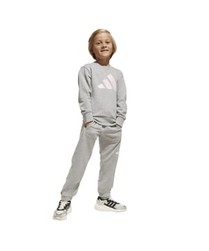 Infant adidas Essentials Joggers Set in medium grey heatherEvery kid's wardrobe needs a versatile set like this. Soft fleece keeps them cosy when they're hanging outside or lounging on the couch. Whether they wear these pants and sweatshirt as a set or mix and match with their other favourite clothes  3 Bar Logos bring a touch of adidas style to any outfit.By choosing recycled  we are able to reuse materials that have already been created  which helps to reduce waste. Renewable materials choices will help us to remove our reliance on finite resources. Our products made with a blend of recycled and renewable materials feature at least 70% total of these materials.- A kids' set made in part with a blend of recycled and renewable materials.- Regular fit with mid rise- Crewneck- 70% cotton  30% polyester (recycled).  Machine wash warm.- Ribbed cuffs and hem on sweatshirt- Elastic waist and cuffs on pants- Front pockets on pants- Contains a minimum of 70% recycled and renewable content- Ref: JC9727