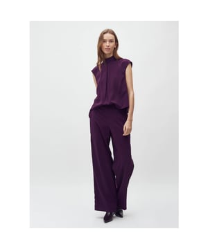
De Maaja van het merk mbyM is een stijlvolle en veelzijdige bordeaux rode mouwloze jumpsuit. Deze mouwloze jumpsuit in diepe bordeauxrode tint is gemaakt van een duurzame gerecyclede polyestermix en heeft een elegante uitstraling die moeiteloos werkt voor zowel een casual dag als een chic diner. De hoge hals en rechte, wijde pijpen geven het ontwerp een moderne, minimalistische look, terwijl de subtiele split met knoopsluiting op de rug zorgt voor een verfijnd detail.
Dankzij de losse pasvorm en soepele stof zit de Maaja heerlijk licht en comfortabel. Draag ‘m met een blazer voor een zakelijke look, of combineer met hakken voor een avond uit.
Product details:

Merk: mbyM
Model: Maaja-M
Kleur: Bordeauxrood (T61 Blackberry Wine)
Mouwloos
Hoge hals
Elegante knoopsluiting in de nek
Wijde rechte pijpen
Steekzakken
Losvallende pasvorm
Materiaal: 54% gerecycled polyester, 43% polyester, 3% elastaan
Valt normaal op maat
Het model is 178 cm lang en draagt maat S
