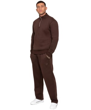 The Enzo Milano Men’s Tracksuit includes a half zip sweatshirt with funnel neck and relaxed fit open hem joggers. The sweatshirt delivers a regular fit, brushed back fleece lining, and ribbed cuffs and hem, finished with the iconic Enzo Milano metal badge. The joggers feature an elasticated drawcord waistband, two side pockets, a back welt pocket, and a straight-leg design with stitched hems for a clean finish. Complete with the bold Enzo Milano rubber print, this men’s zip sweatshirt and jogger set is perfect as a casual tracksuit, streetwear outfit, or everyday loungewear.