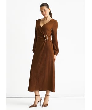 Este vestido midi de jersey marrón combina comodidad con un estilo atrevido. Su diseño cruzado realza tu figura, mientras que el tejido texturizado añade una sutil profundidad. Rematado con un elegante ribete metálico, ofrece un toque moderno perfecto para salidas informales o reuniones relajadas. Fácil de llevar y chic sin esfuerzo, este vestido es una prenda versátil para tu armario.