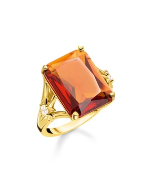 Thomas Sabo Gold Plated Ring with Large Stone. Yellow gold-plated 925 Sterling Silver cocktail ring for women. Expressive piece of jewellery with a glass-ceramic stone in the centre. High quality jewellery with handcrafted cuts and detailing. Looking at this shimmering large glass-ceramic stone with a deep orange colour is like seeing an impressive sunset. Its octagon cut and the open ring settings strengthen the radiant shine. Two crescents and two star-shaped frames with white zirconia stones embellish the sides of this golden ring. The interplay of material and design creates a shimmering eye-catcher for special events. With this golden stone ring, the next magical sunset is always close to you. Material: 100% 18k Gold Plated Sterling Silver (Recycled). Ref: TR22619718.