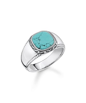 Thomas Sabo zegelring. Glanzend gepolijste, gladde en licht hoekige inleg van imitatie turkoois. Fijne gravures rond de ringkop in een tijgerpatroon en langs de zijkant van de ringrail in koordlook. Aangenaam om te dragen doordat de ringrail aan de binnenkant licht afgerond is. Als unisex ring kan het ook als ongewone partnerring worden gedragen. De kleur turkoois zou een helende werking hebben. Het roept de positieve kracht van de zee op. Materiaal: 100% Sterling Zilver (Gerecycled). Ref: TR238887817.