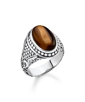 Southwest-Native-American influence. Energetic companion: This signet ring becomes a powerful statement thanks to the tiger’s eye centre stone. The high-quality natural stone is believed to provide safety and promote attention and concentration. The vintage cut of the stone, the finest engraving lines and the unique tendril ornamentation of the iconic THOMAS SABO design language refine this extraordinary piece of jewellery down to the last detail. Material: 100% Sterling Silver (Recycled). Ref: TR22418262.